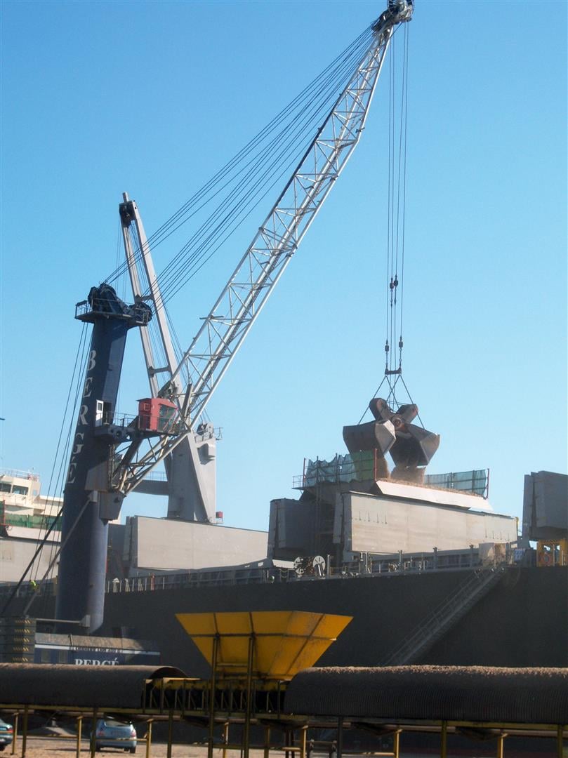 Unloading biomass ship with scissors grab
